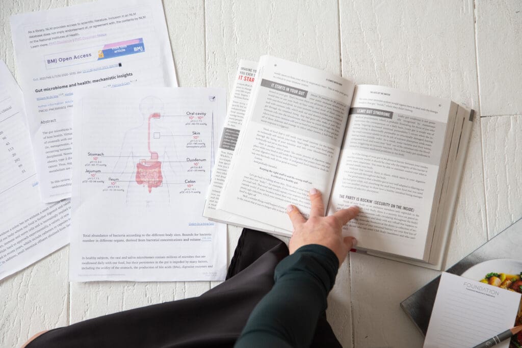 Branding photo of a functional health provider studying scientific papers and diagrams of the human digestive system