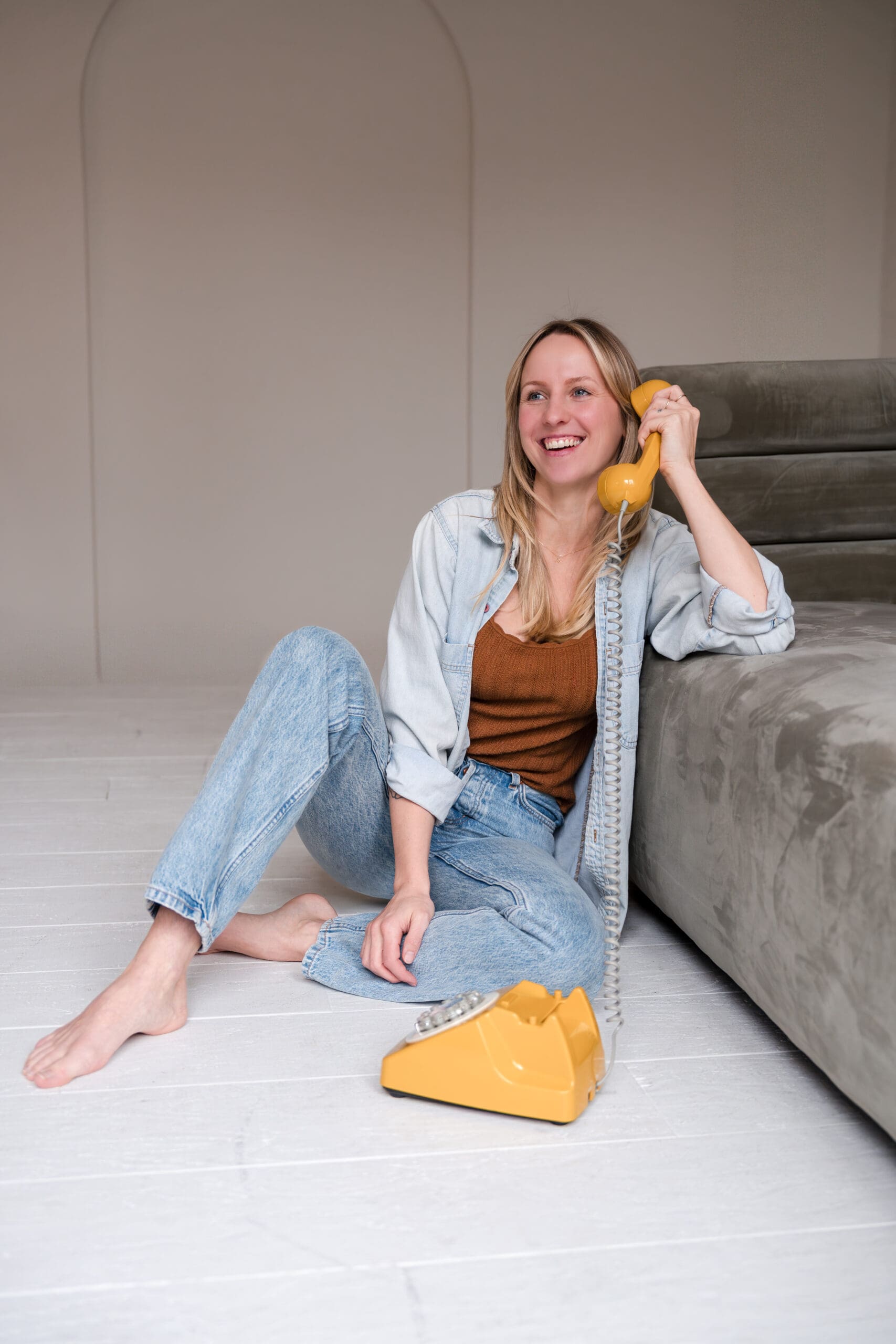 Boise branding photography session for aesthetic wellness clinic holding phone up to her ear talking on phone 