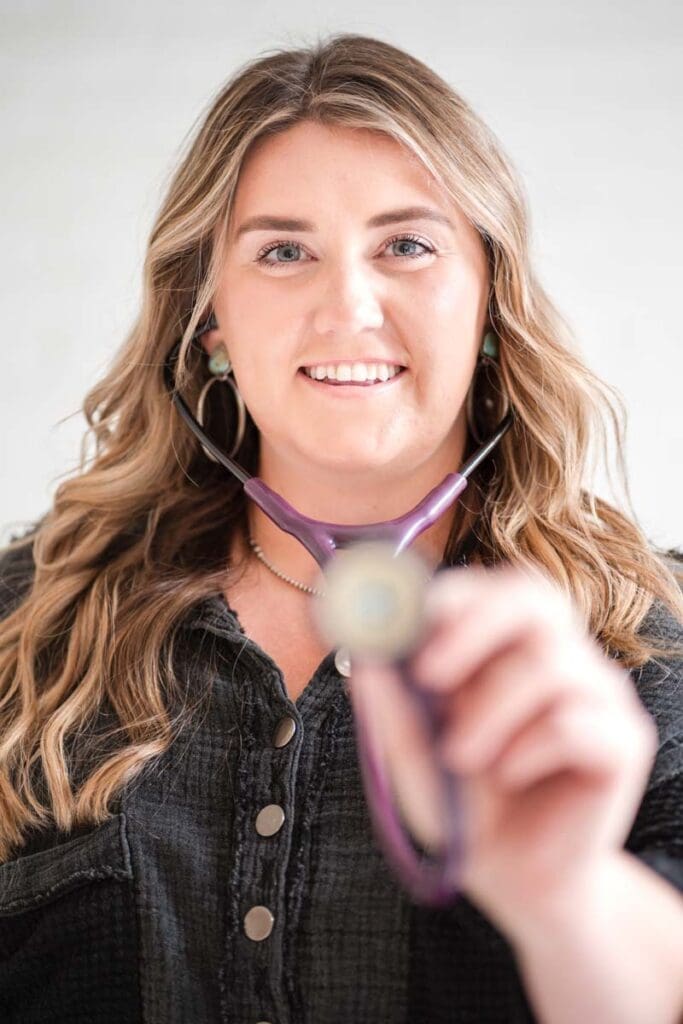Nurse practitioner holding stethoscope up towards camera during boise branding photographer shoot