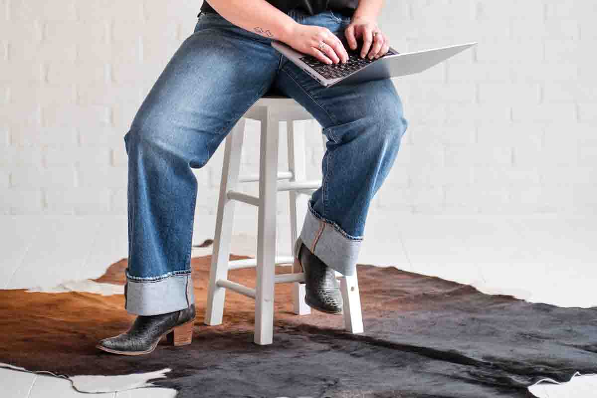 Boise medical practitioner typing on laptop while sitting on stool with a cowhide on the floor