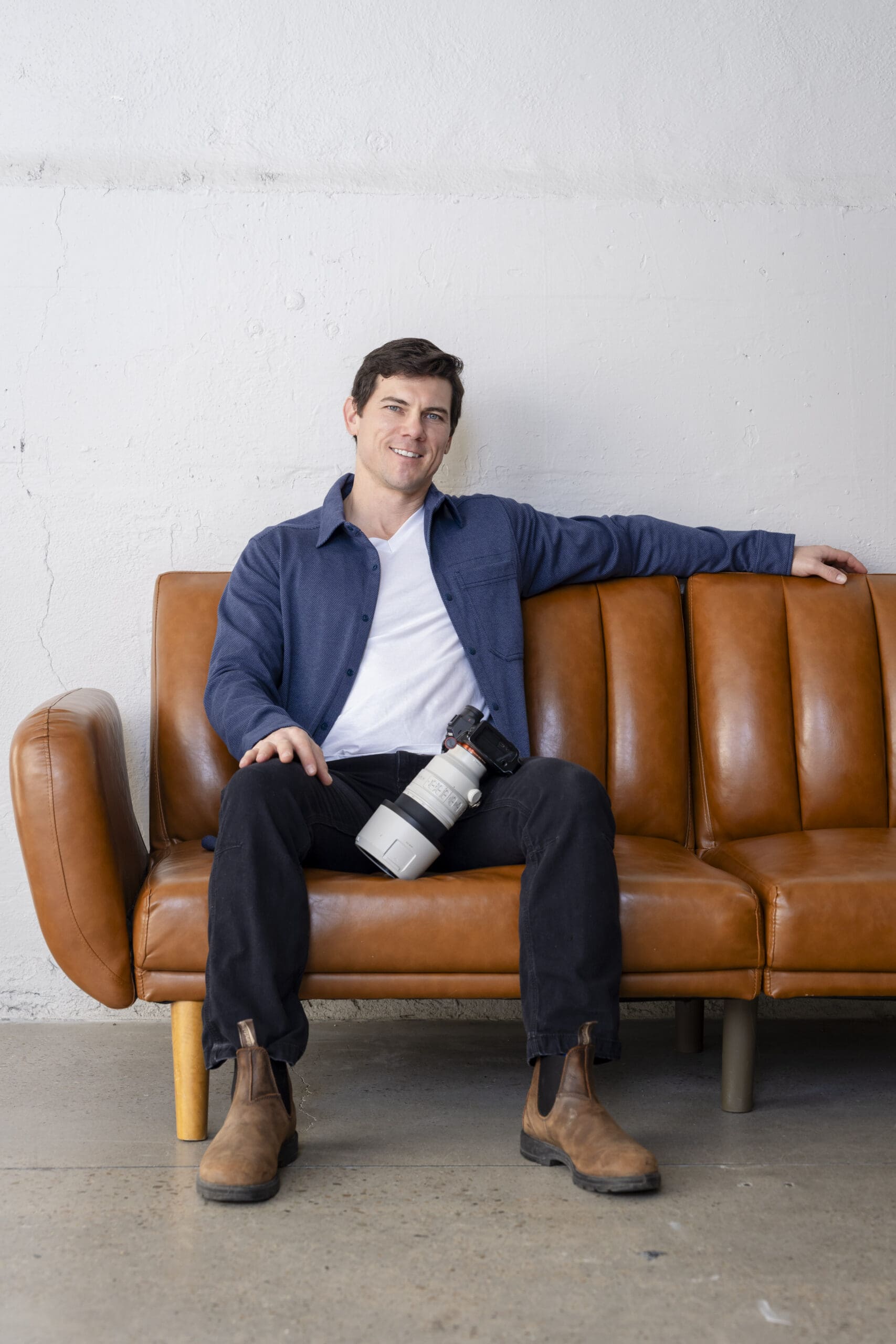 Boise Branding Photographer sitting on couch with a camera on lap