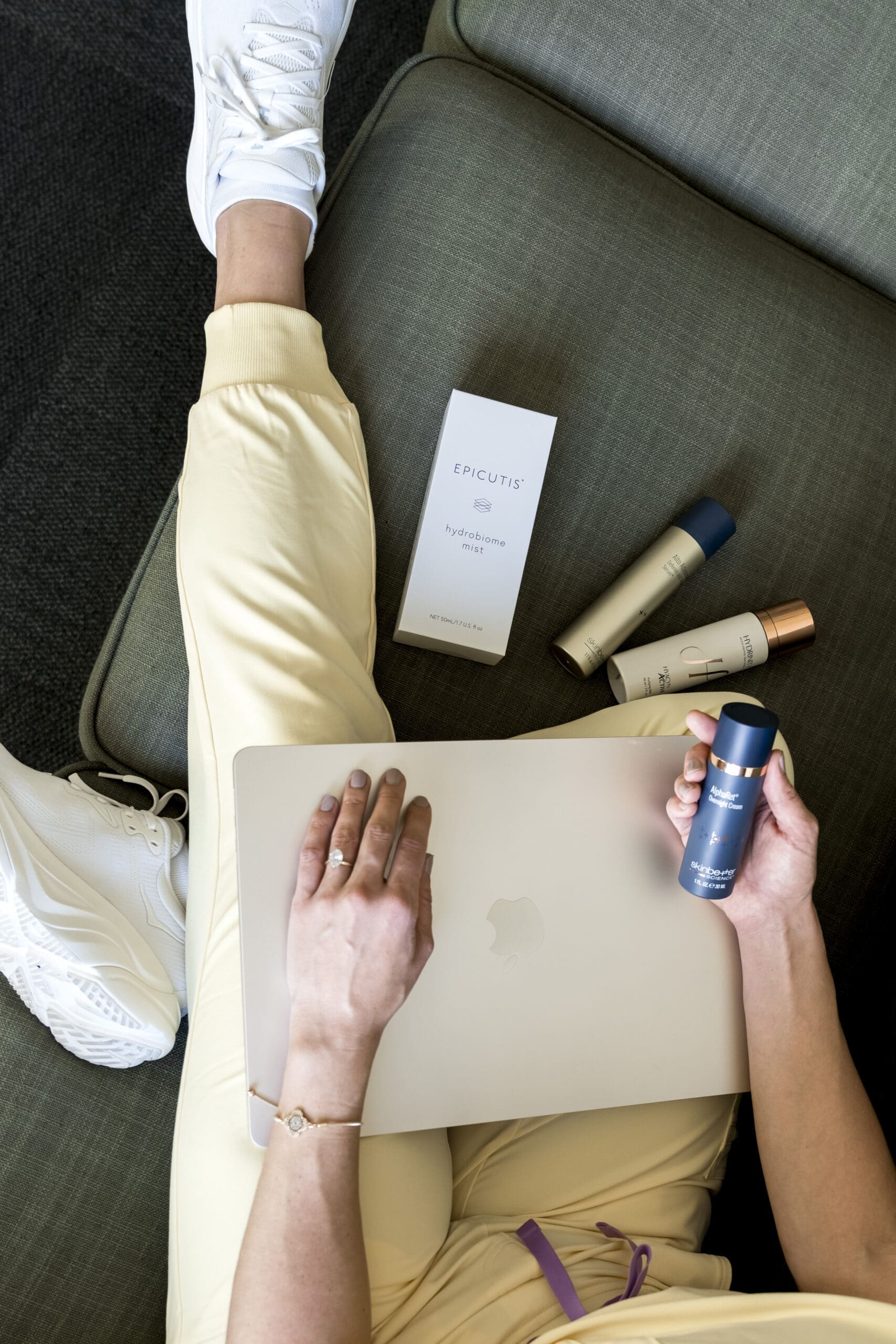 Flat lay branding image of skincare products, laptop, and medical aesthetics workspace
