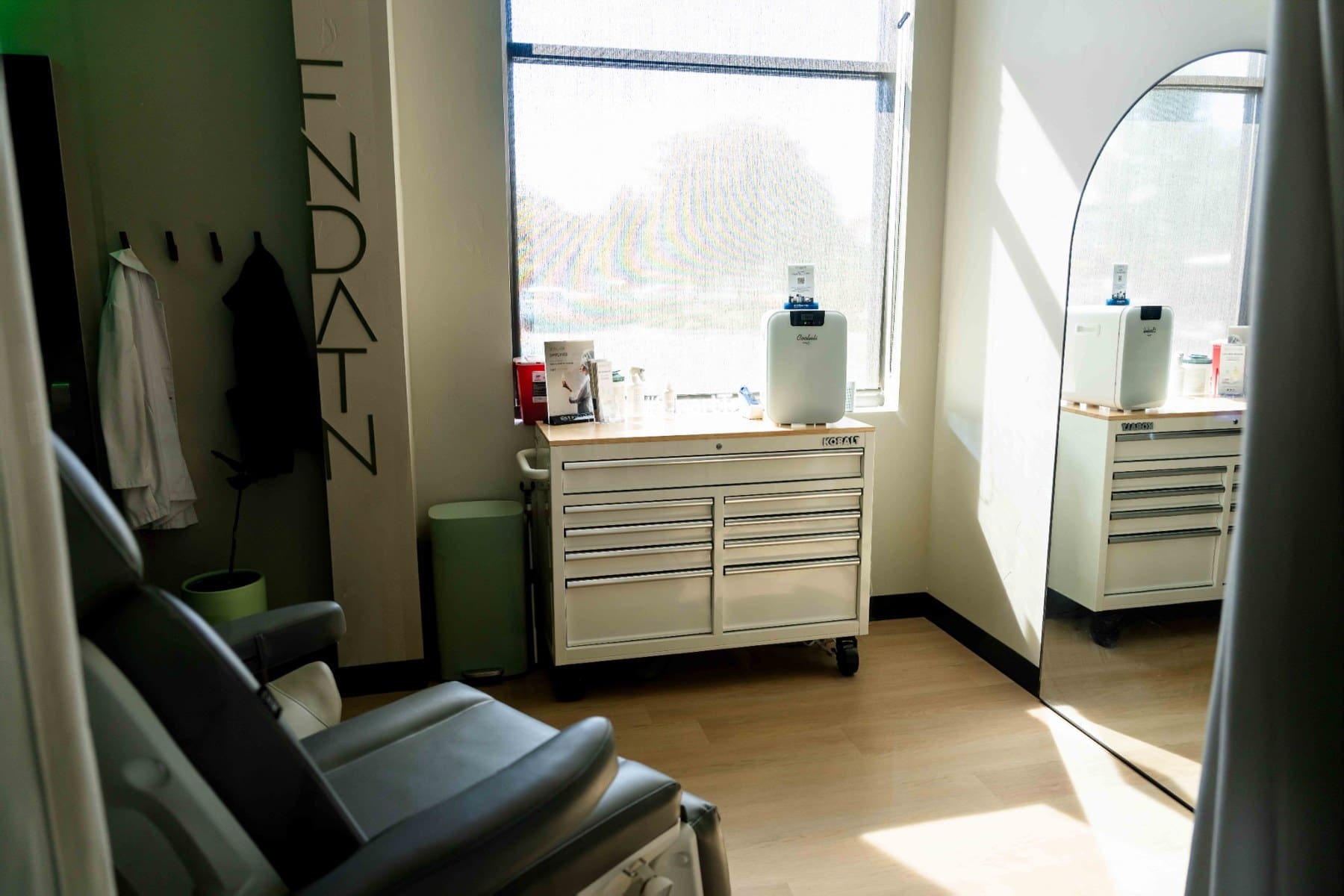 Treatment chair beside a window and white storage cabinets
