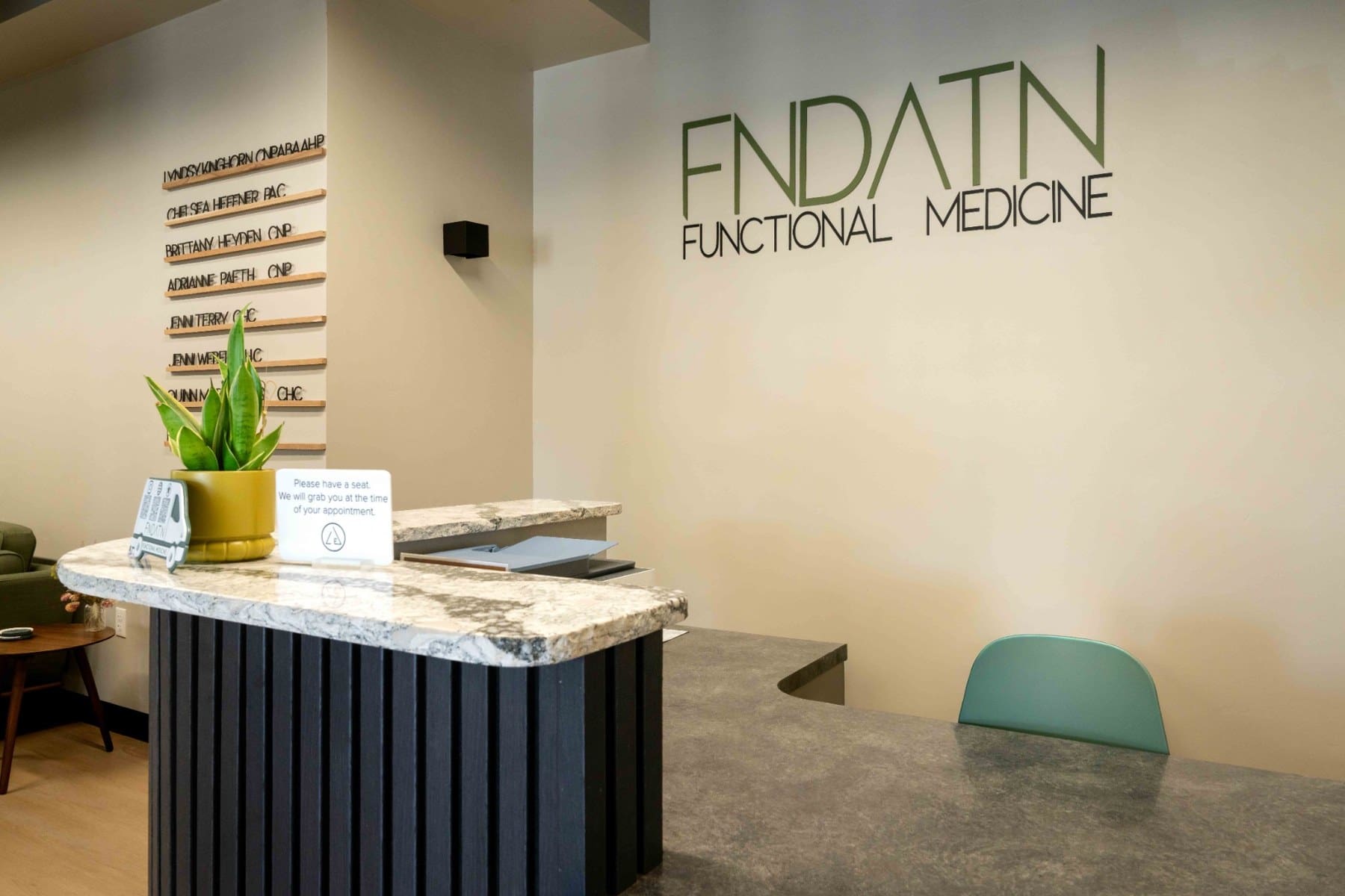 Reception desk beneath the functional medicine practice logo